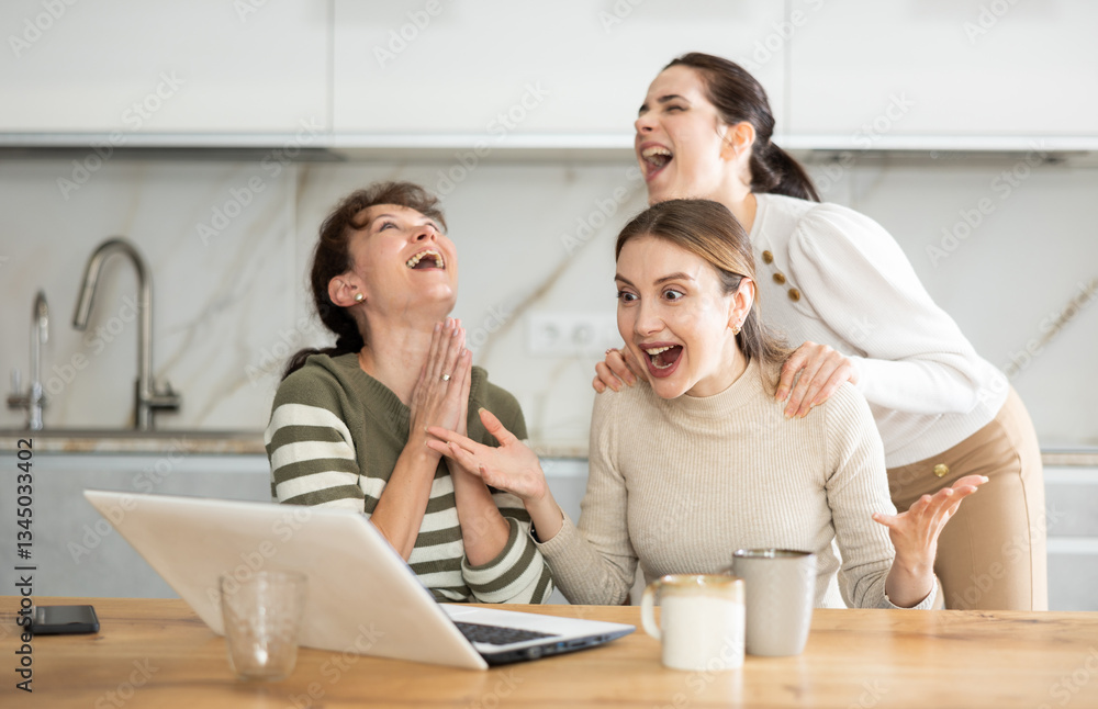 Gleeful ladies in their middle years exulting over big premium in internet while sitting in their house Gleeful ladies in their middle years exulting over big premium in internet while sitting in their house