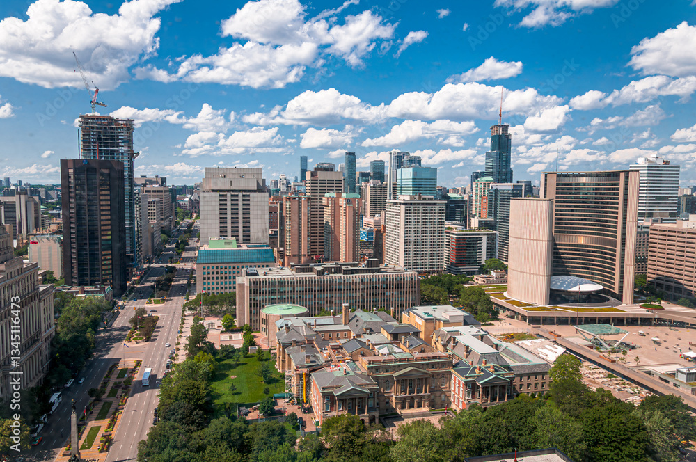 Obraz premium Aerial view of downtown Toronto with skyscrapers, historic buildings, and City Hall. A bright summer sky with clouds adds depth to the vibrant urban landscape.