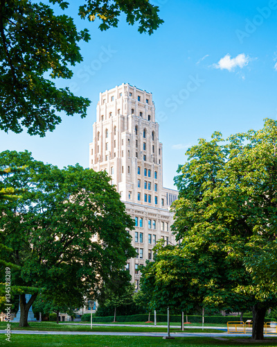 Photography A stunning historic skyscraper rises above lush green trees in Toronto