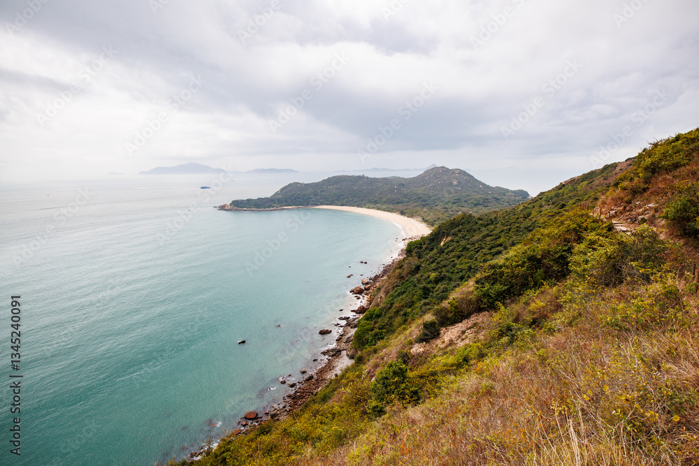 Serene Coastal Landscape with a Curved Beach in a Cloudy Day Serene Coastal Landscape with a Curved Beach in a Cloudy Day