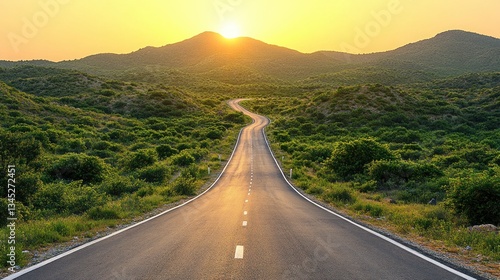 Winding road leading to sunrise over hills