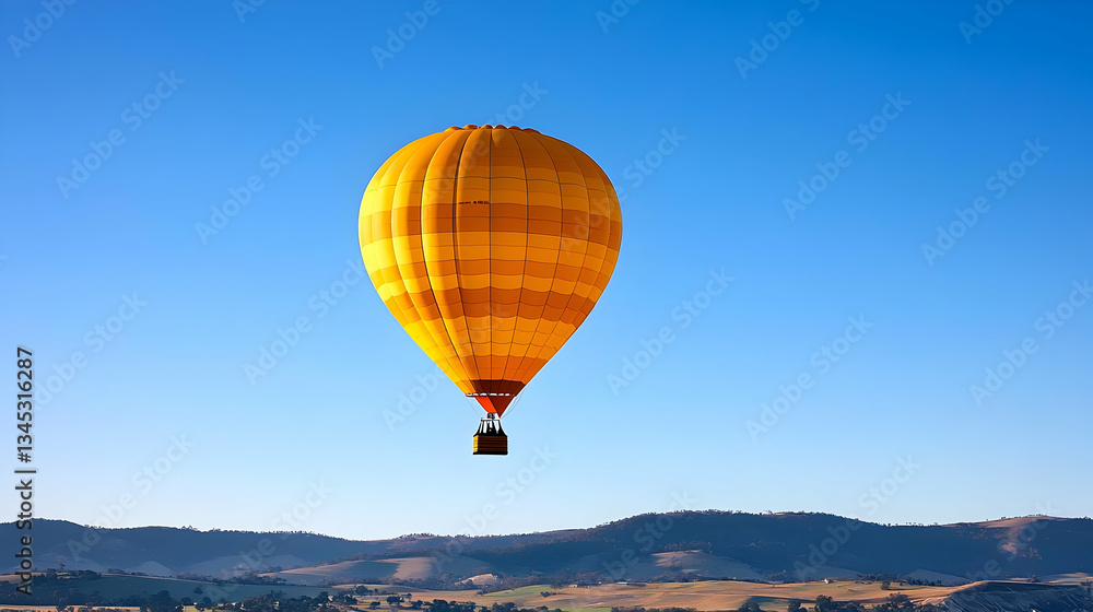 Obraz premium Yellow Hot Air Balloon Floating in Bright Blue Sky During Daytime with Distant Mountain Range