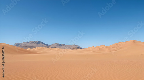 Sandy Desert Landscape With Rolling Dunes Under A Clear Blue Sky With Distant Mountains