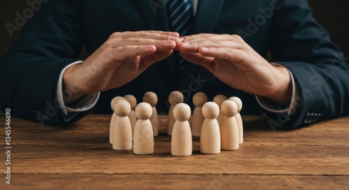 Protective Hands Over Wooden Figures On Dark Wooden Table