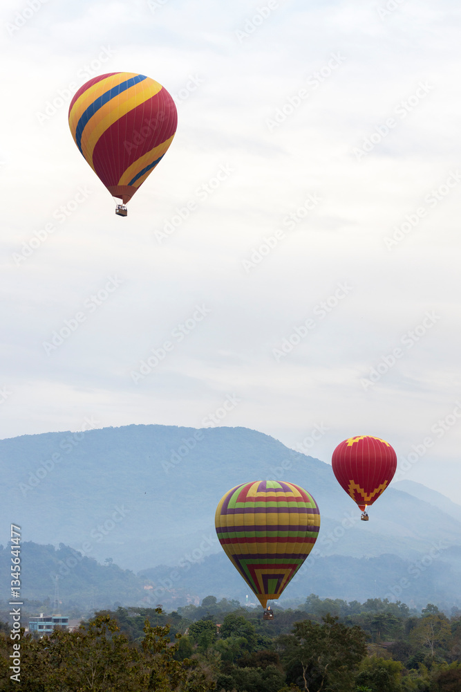 Fototapeta premium Colorful hot air balloons flying over mountain