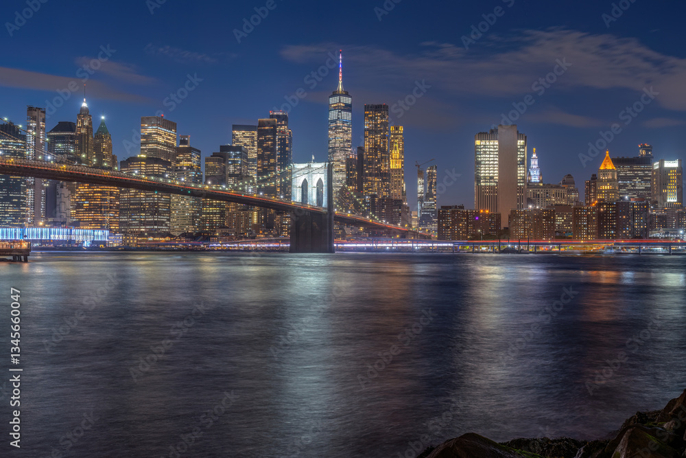 Fototapeta premium The iconic Brooklyn Bridge and the skyline of lower Manhattan in New York City at night