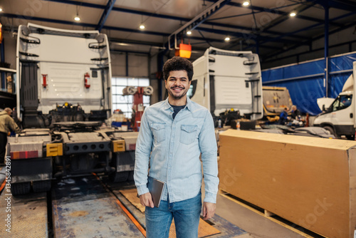 Foto Portrait of happy interracial trucking company manager with tablet smiling at camera