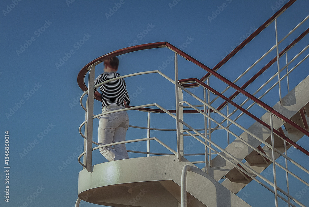 Woman day dreaming on luxurious transatlantic crossing aboard the luxury ocean liner cruise ship Queen Mary with views of the ocean and seascape until horizon with sunset