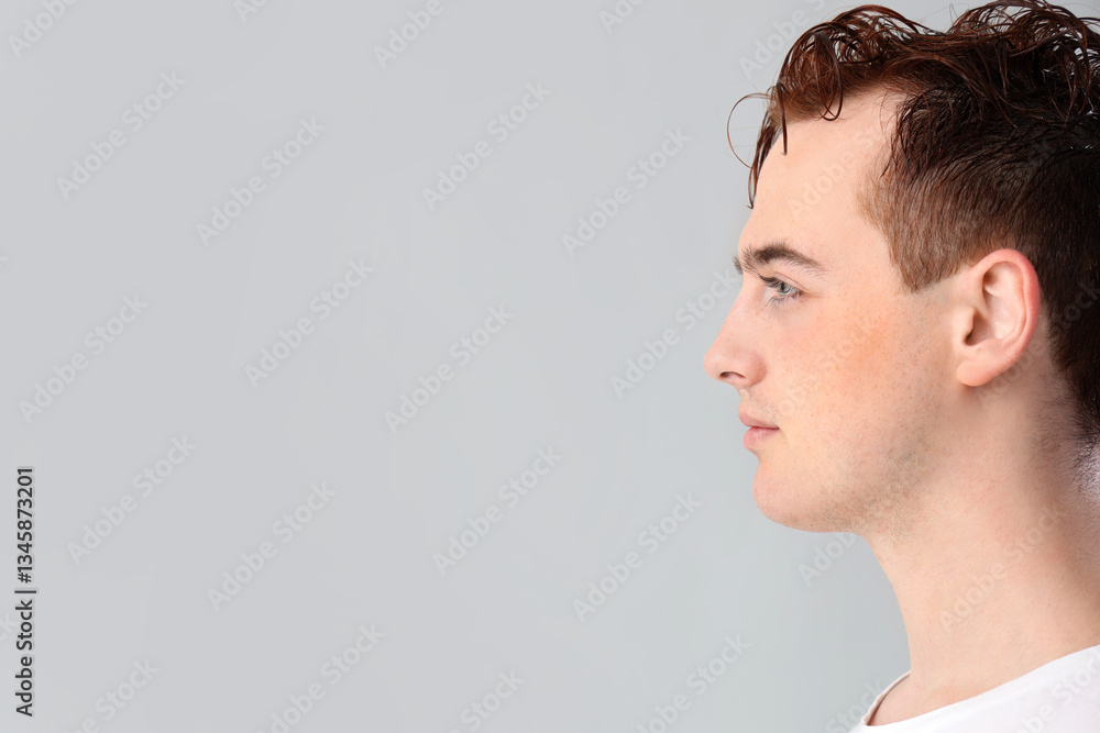 Obraz premium Young man with wet hair on light background
