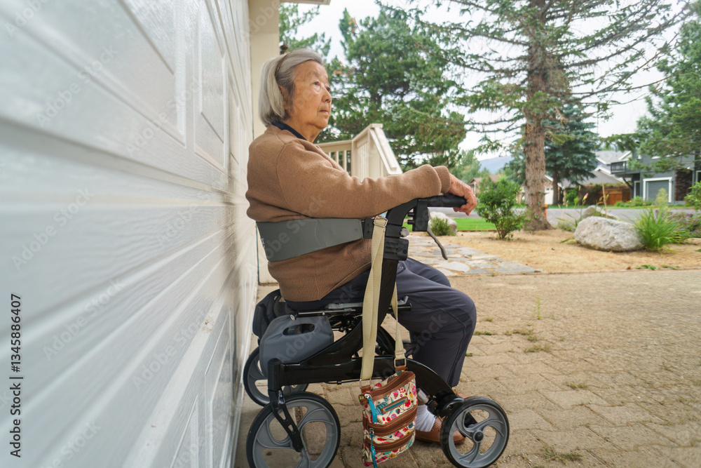 Elderly woman resting on a mobility walker outside the house. California, USA.
