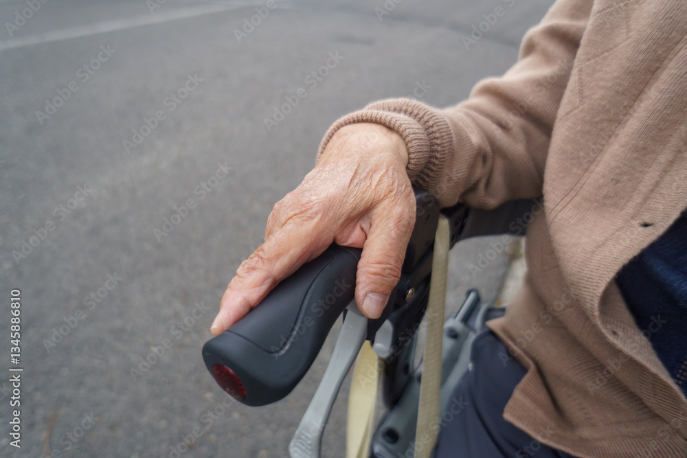 Hand of a senior woman resting on a mobility walker.