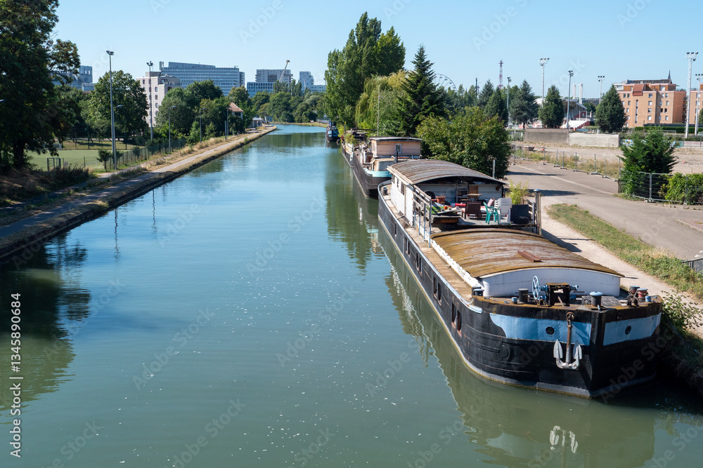 Naklejka premium boat is floating on a river with a city in the background. The water is calm and the sky is clear. Strasbourg, France