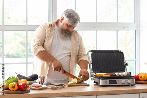 Mature man cooking tasty sa...