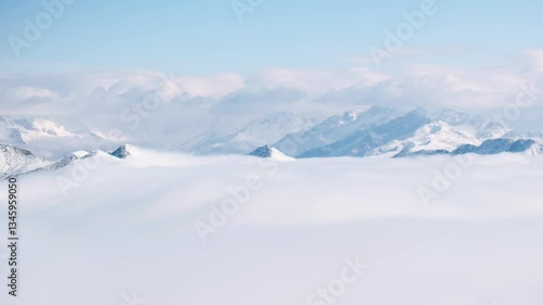 aerial view timelapse of winter snow mountain landscape with clouds mist moving