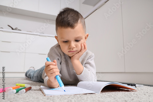Young boy drawing in a note...