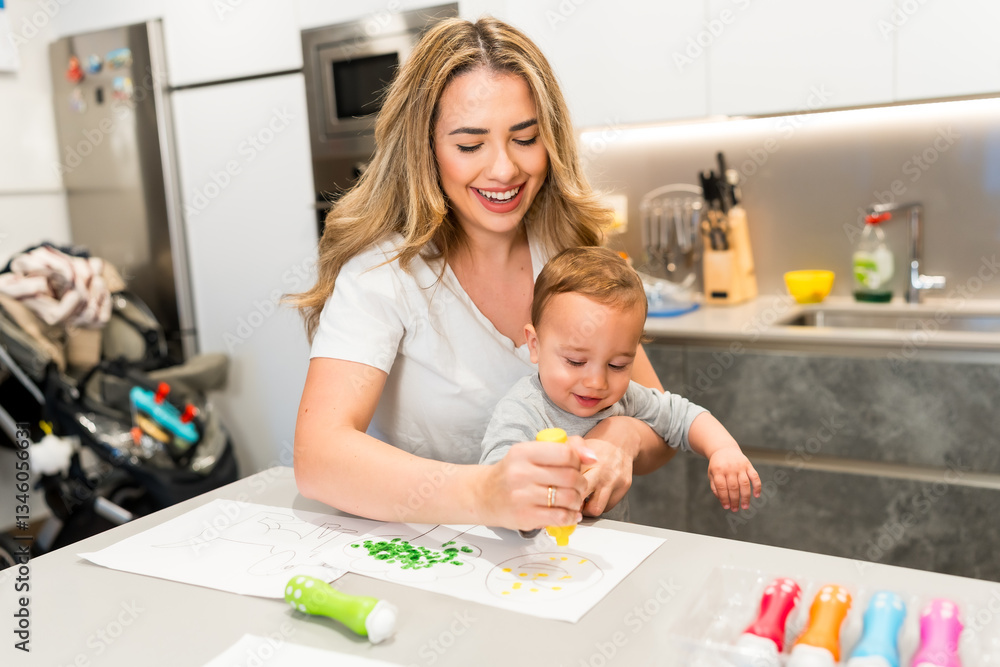 Fototapeta premium Mother and baby painting together in modern kitchen