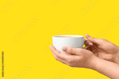 Female hands holding cup of...