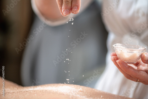 Scrubbing back massage uses Himalayan, Dead Sea, or Epsom salts mixed with coconut, almond, or essential oils, exfoliating skin, unclogging pores, and promoting smoother, healthier skin.