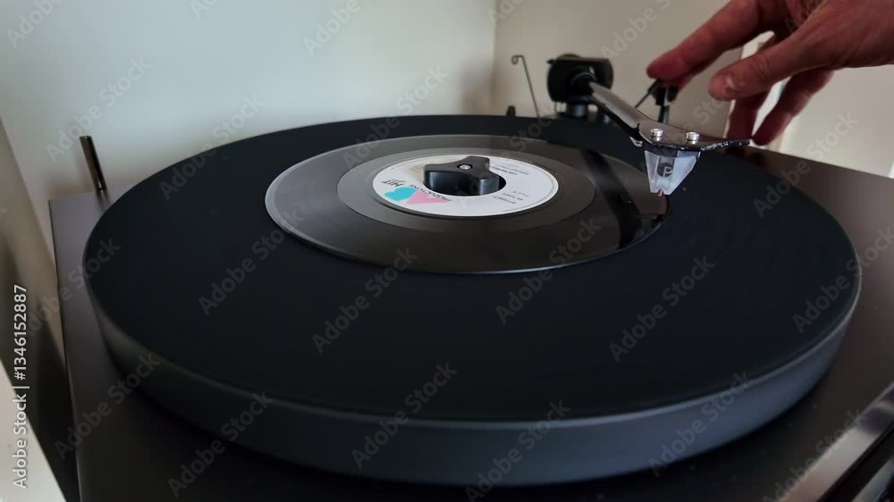 Turntable spinning vinyl record with hand adjusting tonearm during the play. Turntable spinning vinyl record with hand adjusting tonearm during the play.