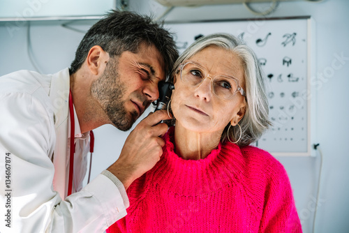Wallpaper Mural Doctor examining senior woman's ear with otoscope in medical clinic Torontodigital.ca