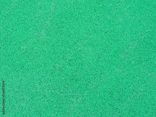 green single color textured grainy background material close-up full frame, rubber crumb coating for sports and fitness and for paving playgrounds, soft springy elastic artificial material