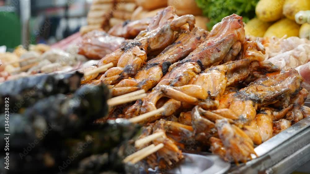 Fried frogs are neatly stacked on skewers, their crispy skin revealing a golden texture. An adventurous delicacy at this vibrant food stall. Fried frogs are neatly stacked on skewers, their crispy skin revealing a golden texture. An adventurous delicacy at this vibrant food stall.