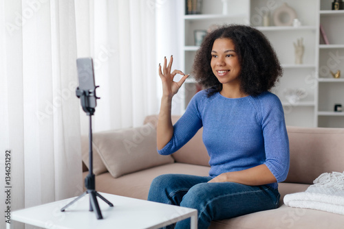 Vlogging Concept. Young Smiling Black Woman Capturing Video At Home, African American Female Blogger Sitting On Couch, Talking At Smartphone Camera And Showing Ok Gesture Free Download Vlogging Concept. Young Smiling Black Woman Capturing Video At Home, African American Female Blogger Sitting On Couch, Talking At Smartphone Camera And Showing Ok Gesture - GFXLoad