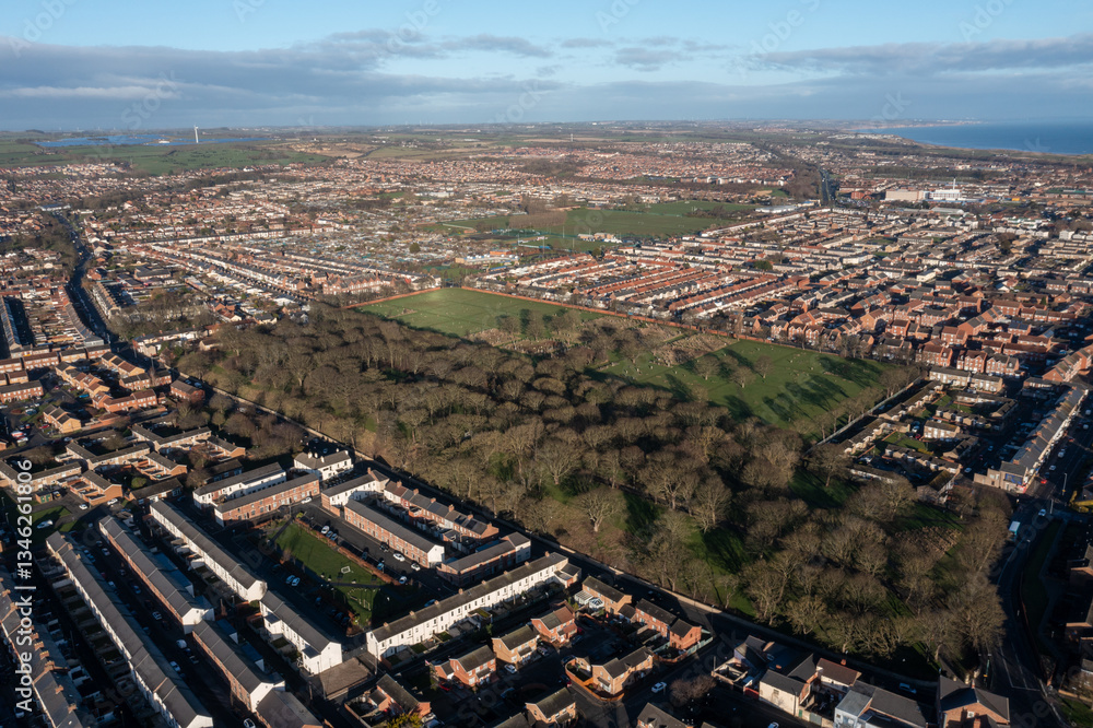 Aerial drone photo of the town of Hartlepool in the UK showing rows of terrace houses and homes and typical British suburban housing estates with the ocean in the background in the winter time