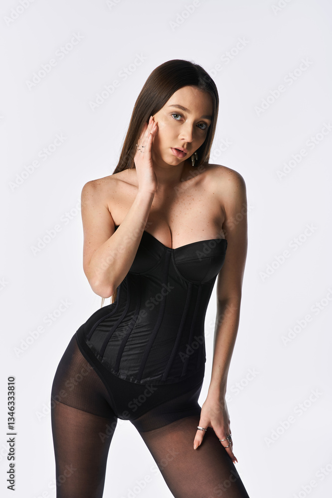 Naklejka premium Stylish young woman showcasing modern elegance with confidence and grace in a minimalist setting