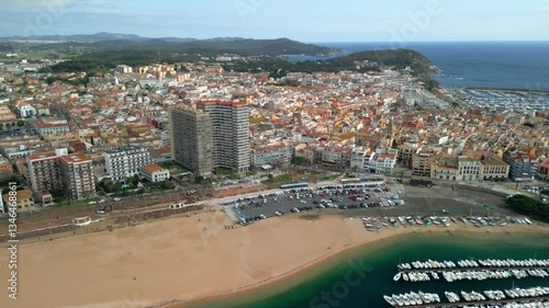 Sant antoni de calonge, a charming coastal town on the costa brava in spain, reveals its beauty from an aerial perspective, showcasing the beach, colorful buildings, and boats moored in the harbor
