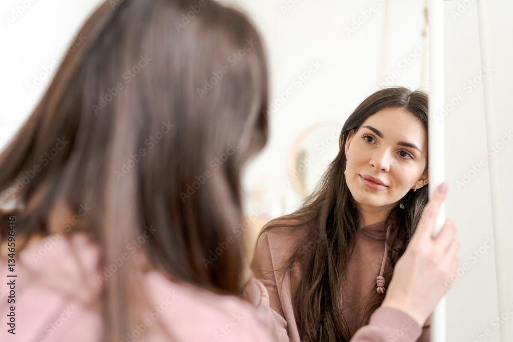 Woman is looking at her reflection in a mirror Woman is looking at her reflection in a mirror