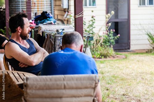 Two men chatting together on verandah