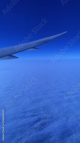 Looking through the airplane window at night, there are clouds in the sky.