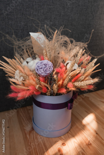 Photos Dried flower arrangement in a hat box with ribbon.
