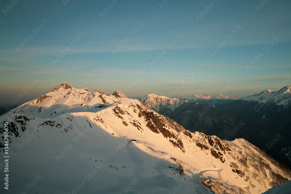 Fototapeta premium Snow-capped Caucasus Mountains at dawn, Sochi, Russia.