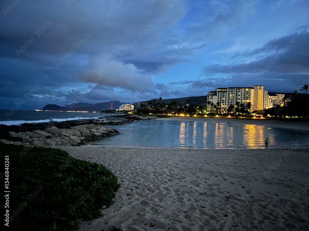 Ko Olina coastline on Oahu Hawaii on a cloudy evening, yellow lights reflecting off the water Ko Olina coastline on Oahu Hawaii on a cloudy evening, yellow lights reflecting off the water