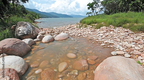 Tranquil Lakeside Scene with Smooth Stones and Lush Greenery