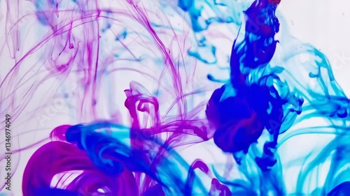 Colors blend of purple and blue flow as ink liquid drips gracefully, forming intricate patterns against a smooth backdrop. The fluid motion captivates with its dynamic elegance.