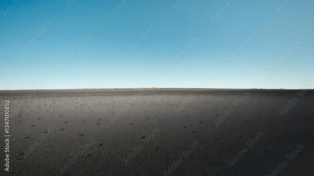 Obraz premium Barren Horizon: An expansive and desolate landscape of a barren ground, stretching endlessly beneath a vast, clear blue sky, evoking a sense of solitude and the raw power of nature.