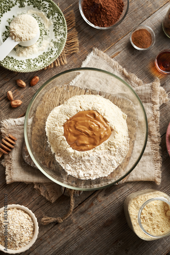 Whey protein powder, oat flakes, nut butter, maple syrup and raw cacao - ingredients for homemade protein chocolate bars Whey protein powder, oat flakes, nut butter, maple syrup and raw cacao - ingredients for homemade protein chocolate bars