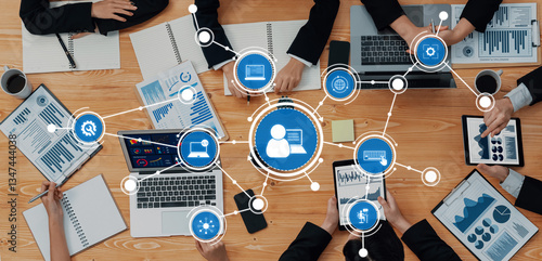 Quadro em tela Diverse team members engage in a collaborative business meeting, utilizing digital devices to analyze data and generate insights with vibrant visual presentations around a workspace