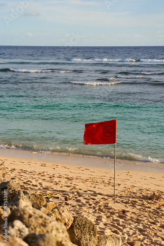 Obraz na płótnie A red flag is posted on the ocean beach due to the risk of a possible storm. w salonie