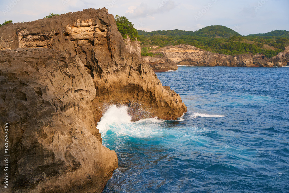 Cinematic aerial landscape shots of the beautiful island of Nusa Penida. Huge cliffs by the shoreline and hidden dream beaches with clear water and foaming wave.