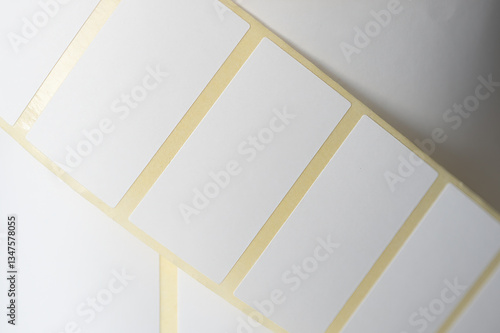 Close-up of blank adhesive label stickers roll. A detailed close-up of a roll of blank adhesive label stickers with rectangular shapes, commonly used for printing, packaging, and organization.  

