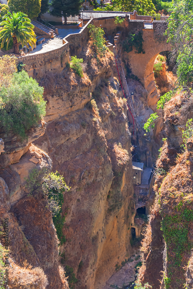 The rocky, sheer-sided limestone cliffs of Ronda Gorge (El Tajo de Ronda) plummet 390 feet (120 meters) to Guadalevin River. Ronda, Province of Malaga, Spain.
