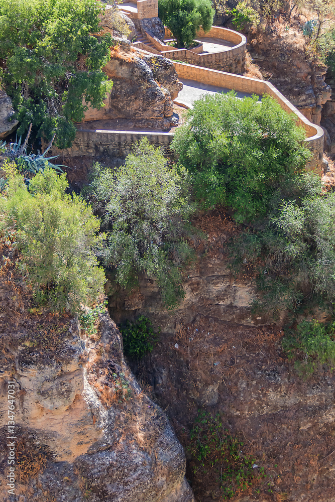 The rocky, sheer-sided limestone cliffs of Ronda Gorge (El Tajo de Ronda) plummet 390 feet (120 meters) to Guadalevin River. Ronda, Province of Malaga, Spain.