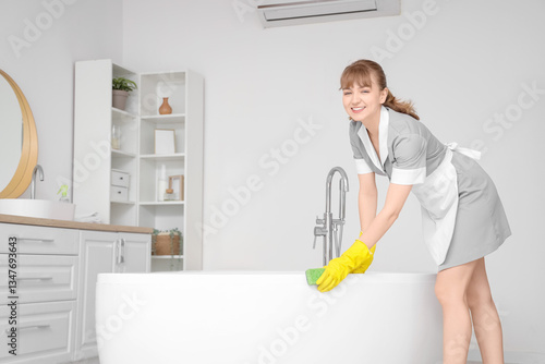 Young chambermaid cleaning ...