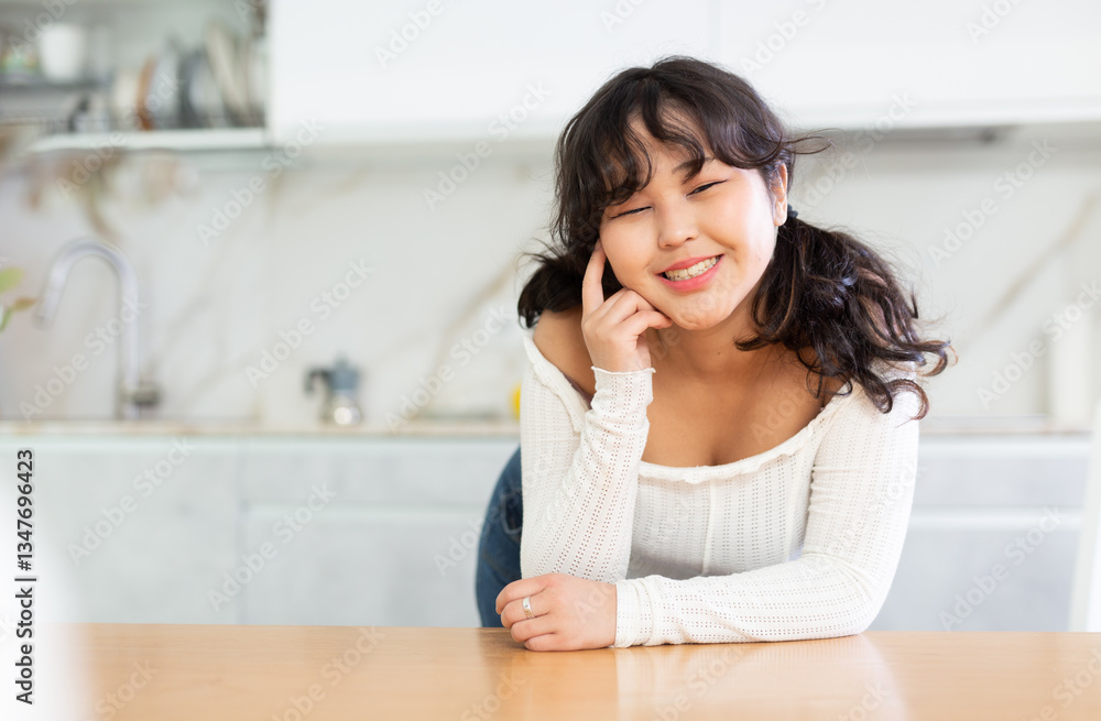Portrait of young asian girl in the interior of a modern kitchen Portrait of young asian girl in the interior of a modern kitchen