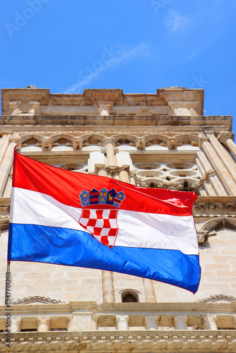 Croatian flag blowing in the wind on the bell tower of The Cathedral of St. Lawrence, landmark in Trogir, Croatia. 