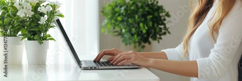 Woman in a business casual outfit using a laptop at her home office, with indoor plants and eco-friendly decor.